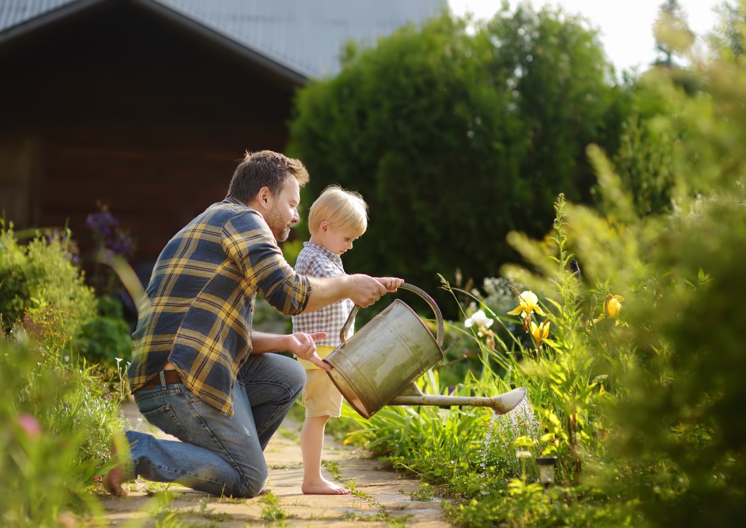un père et son fils arrosent leur jardin